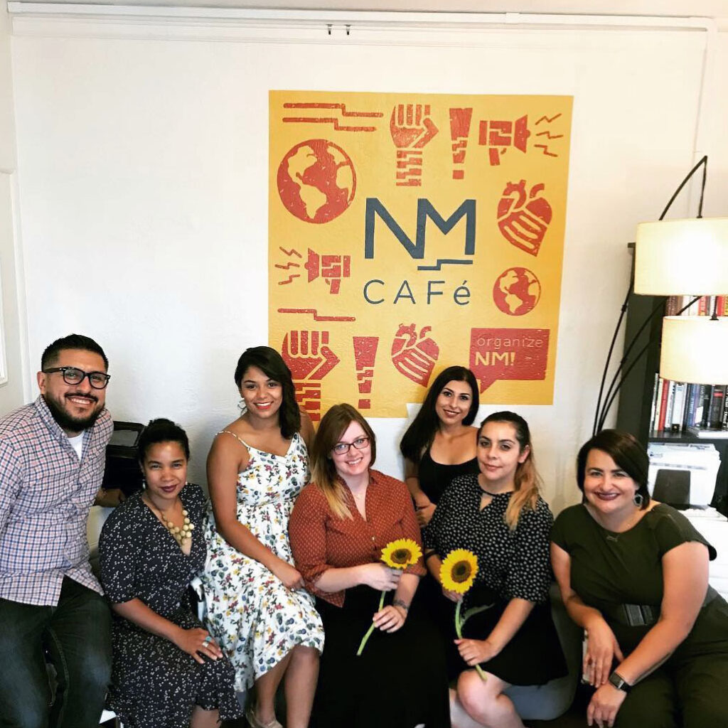 NMCO Studio members in front of a NM CAFE painting