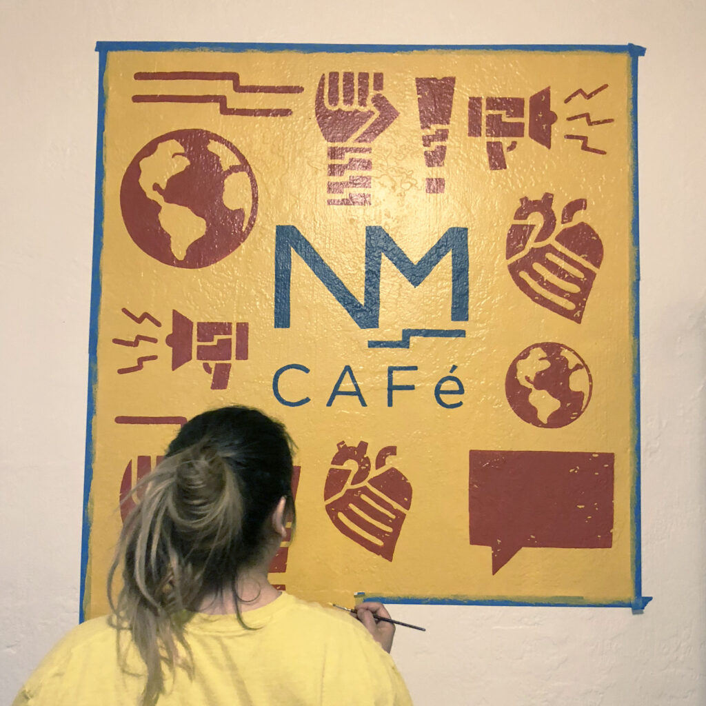 NMCO Studio member in front of a NM CAFE painting